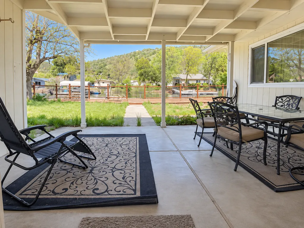 Covered patio with a table, chairs, and a lounge chair.